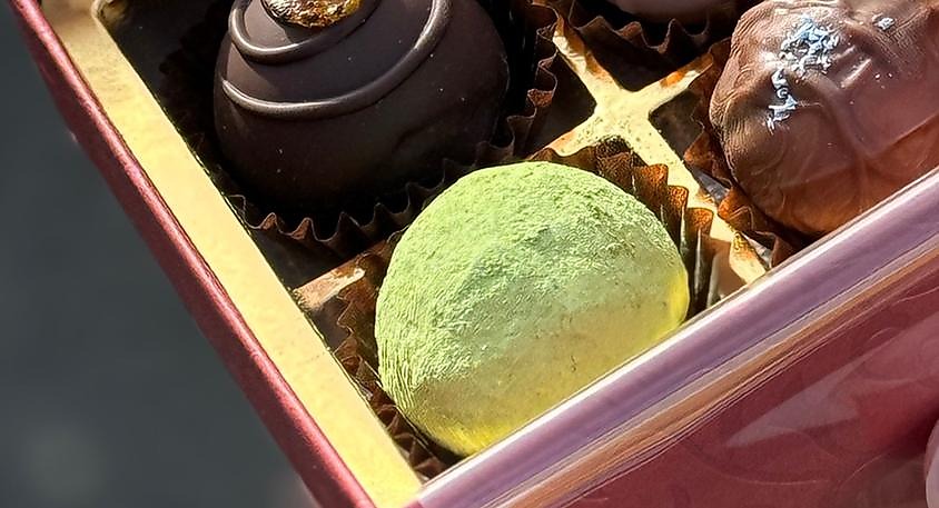 Green mulberry powder dusted mochi truffle in a luxury box of assorted Japanese confections