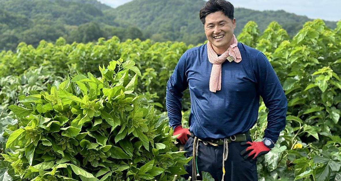 Kuwanosato founder smiling in the mulberry farm fields in Yamanashi, Japan
