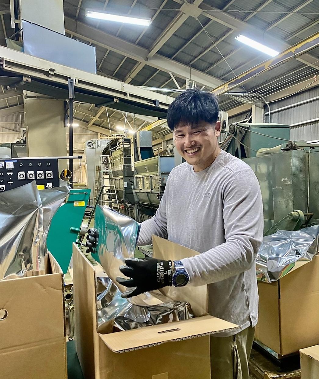 Kuwanosato founder working at the production facility, handling product packaging